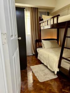 a bedroom with two bunk beds and a wooden floor at East Ortigas Mansions by MA in Manila +12 photos