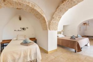 ein Schlafzimmer mit zwei Betten in einem Zimmer in der Unterkunft Trullo Melograno by Perle di Puglia in San Michele Salentino