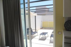a view of a balcony with a table and a clock at Casa Marina 44 in Marina di Ragusa