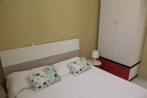 a bedroom with a white bed with two pillows at Casa Marina 44 in Marina di Ragusa