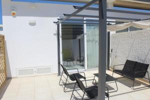 a patio with two chairs and a table on a balcony at Casa Marina 44 in Marina di Ragusa