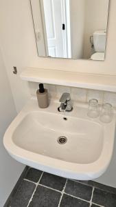 a white sink in a bathroom with a mirror at Vakantiehuis Pippa in Peer