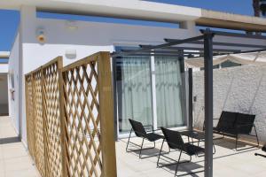 a patio with chairs and a fence on a balcony at Casa Marina 44 in Marina di Ragusa +11 photos