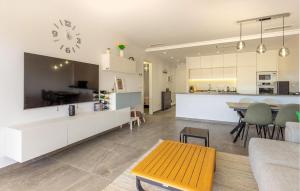cocina y sala de estar con mesa y reloj en Cozy Apartment In Torre De La Horadada, en Torre de la Horadada