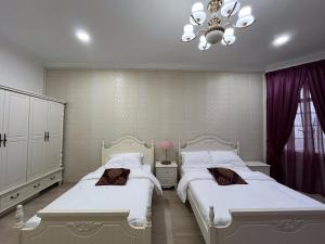 a bedroom with two beds and a chandelier at Titiwangsa Premium Villa KL by uBook in Kuala Lumpur