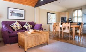 Una sala de estar con un sofá morado y una mesa. en Underscar - Beckstones, en Keswick