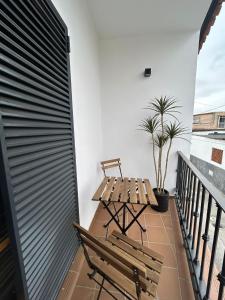 einen Balkon mit einer Holzbank und einem Tisch in der Unterkunft Casa Mariquilla in Sanlúcar de Barrameda