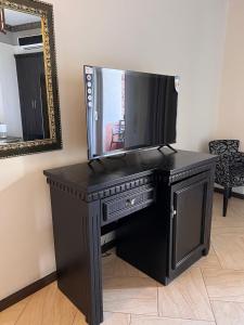 una scrivania nera con una televisione sopra di Sofra Resort a Durrës