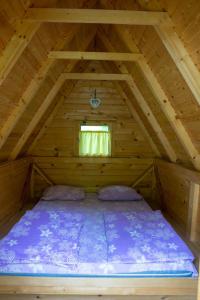 a bed in the attic of a wooden cabin at Grand Tara Rafting Resort in Foča