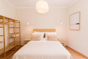 a bedroom with a large white bed with pillows at Casa Telhados Centro Histórico Terraço Privado in Tavira