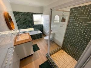 ein Badezimmer mit Dusche, Waschbecken und Toilette in der Unterkunft Waterfront Cottage B2 in Swakopmund + 25 Fotos