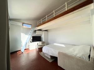 a bedroom with a bunk bed and a ladder in it at Appartement à 100M de la plage - Terrasse & Parking Privé in Le Barcarès