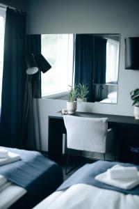 a bedroom with a desk and a chair and a mirror at Live Lofoten Hotel in Stamsund
