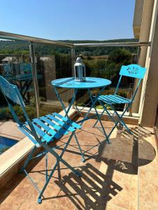 a blue table and two chairs on a balcony at Azur Properties 76 in Shkorpilovtsi