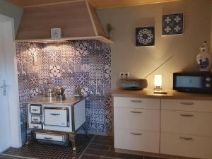a kitchen with a table and a tv on a wall at Ferienwohnung Kanalblick 35520 in Uplengen