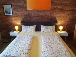 two beds in a room with two lamps on tables at Ferienwohnung Kanalblick 35520 in Uplengen