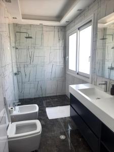 ein weißes Badezimmer mit Waschbecken und Toilette in der Unterkunft Era Palace Apartments in Vlorë + 56 Fotos