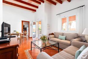 a living room with a couch and a table at Villas Begonias in Cala'n Bosch