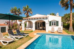 a villa with a swimming pool and a house at Villas Begonias in Cala'n Bosch