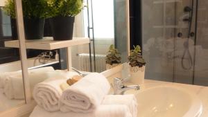 ein Badezimmer mit Handtüchern, einem Waschbecken und einem Spiegel in der Unterkunft Charmante maison de vacances - Le Bono in Le Bono + 42 Fotos