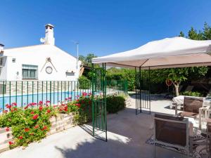eine Terrasse mit einem weißen Sonnenschirm und einem Pool in der Unterkunft Cortijo Valmaruc in Dúrcal