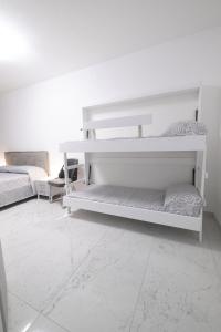 two white bunk beds in a white room at MirabiLuxury in Borgo Fosso Ghiaia