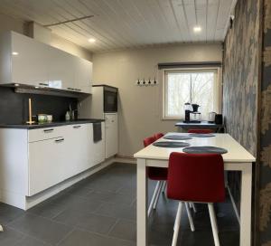 a kitchen with a table and red chairs at Erillistalo keskustassa in Seinäjoki