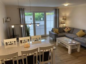 a living room with a table and a couch at Ferienhaus Meer Zeit II in Burhave