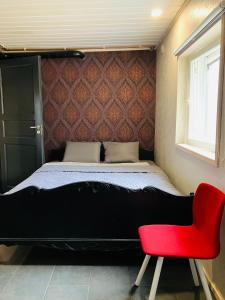 a bedroom with a bed and a red chair at Erillistalo keskustassa in Seinäjoki