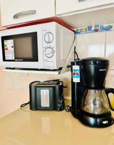 a kitchen counter with a coffee maker and a microwave at Duplex Zona Céntrica in Río Gallegos