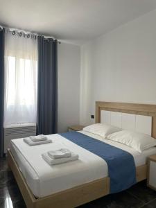 ein Schlafzimmer mit einem Bett mit zwei Handtüchern darauf in der Unterkunft Era Palace Apartments in Vlorë