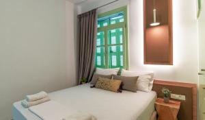 a bedroom with a white bed with a window at Paleochora Central Apartments in Palaiochóra