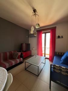 a living room with a couch and a table at colored houses in Ierapetra