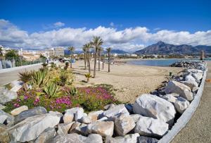 una spiaggia con rocce, palme e acqua di Penthouse with private pool, hot tub jacuzzi with sea views and chill-out zone, close to the sea a Marbella
