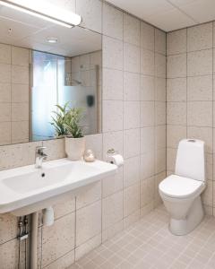 a bathroom with a toilet and a sink and a mirror at Live Lofoten Hotel in Stamsund