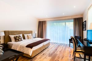 a bedroom with a bed and a desk and a window at Villa Waldesruh in Siegburg