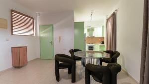 a dining room with a glass table and black chairs at Paleochora Central Apartments in Palaiochóra