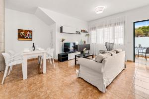 a white living room with a table and a couch at Apartamento Playa Dorada Bajos in Playa Blanca