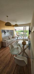 a living room with a glass table and chairs at Infinity Apartman Lellemarine in Balatonlelle