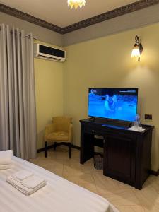 una camera con letto e TV su una scrivania di Sofra Resort a Durrës