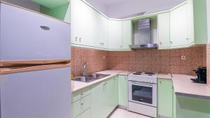 a kitchen with green cabinets and a white refrigerator at Paleochora Central Apartments in Palaiochóra +8 photos
