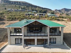 克拉伦斯Golfers View @101的享有绿色屋顶房屋的空中景致