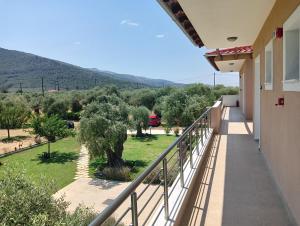 a balcony of a house with a tree at Anatoli Studios in Skala Rachoniou