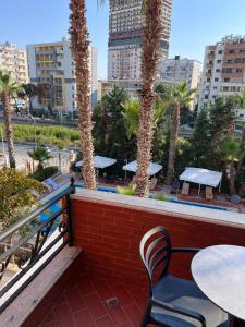 un balcone con tavolo, sedie e palme di Sofra Resort a Durrës