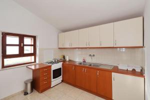 a kitchen with white cabinets and a sink and a stove at Kuća za odmor Island just for You - Ravna Sika in Ravna Sika