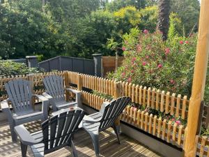 three chairs on a deck with flowers and a fence at Lbkn in Toulouse