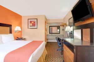 a hotel room with a bed and a flat screen tv at Days Inn by Wyndham Independence in Independence