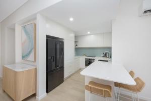 a kitchen with a white counter and a black refrigerator at Gregory Street 31 in Townsville