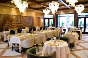 a restaurant with white tables and chairs and chandeliers at The Swiftwater in Swiftwater