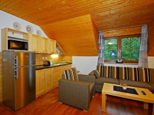 eine Küche und ein Wohnzimmer mit einem Sofa und einem Kühlschrank in der Unterkunft Apartmány a štúdiá Miroslav in Demänovská Dolina